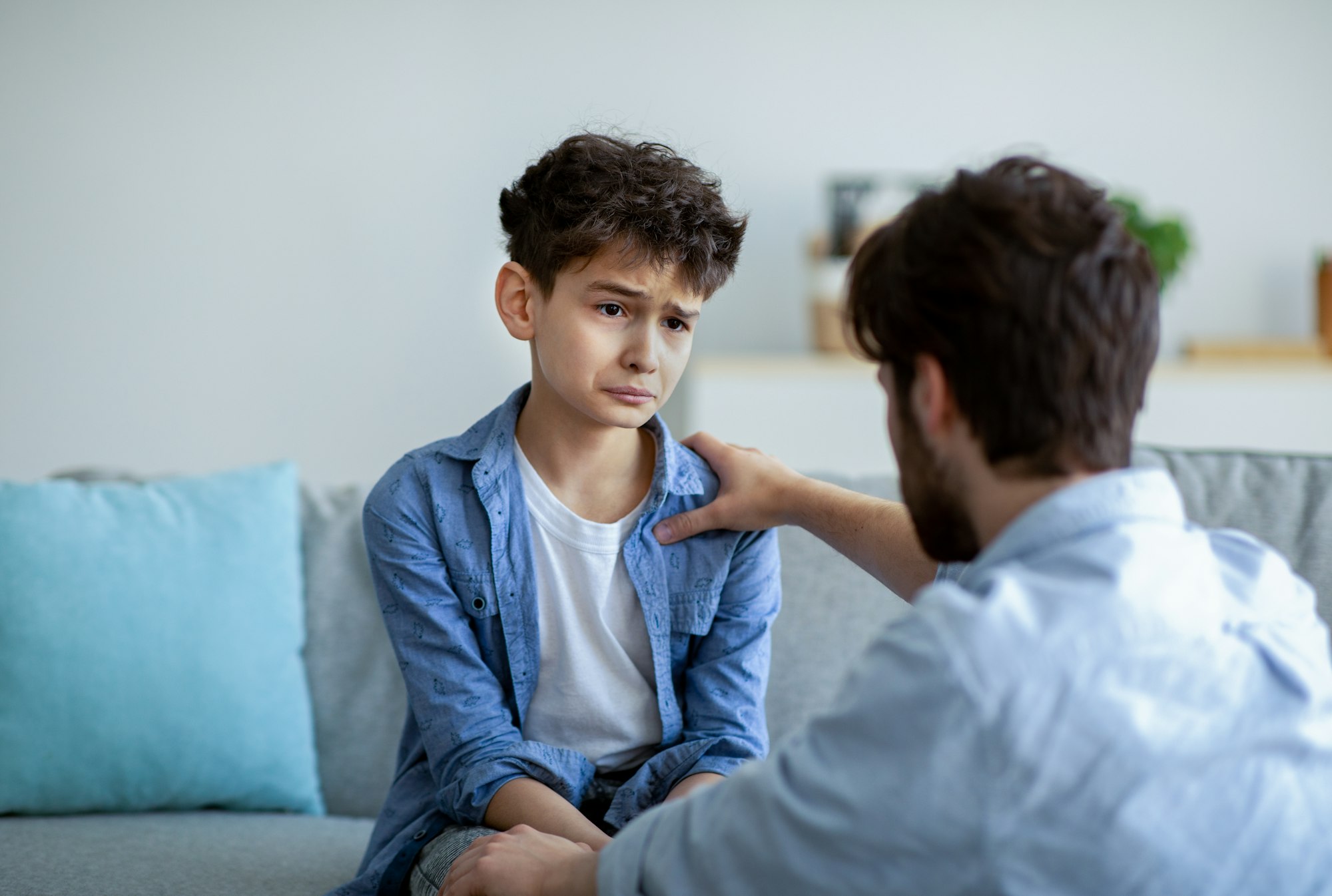 Father and sad son having heart to heart talk at home, daddy trying to solve problems, parent