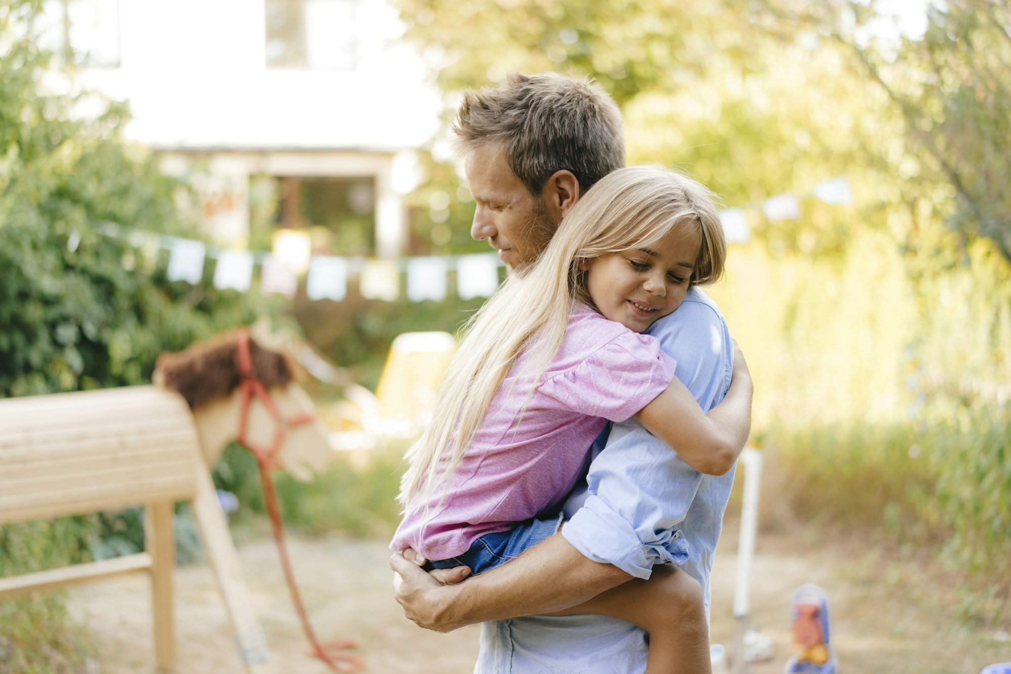 Father cuddling with daughter in garden