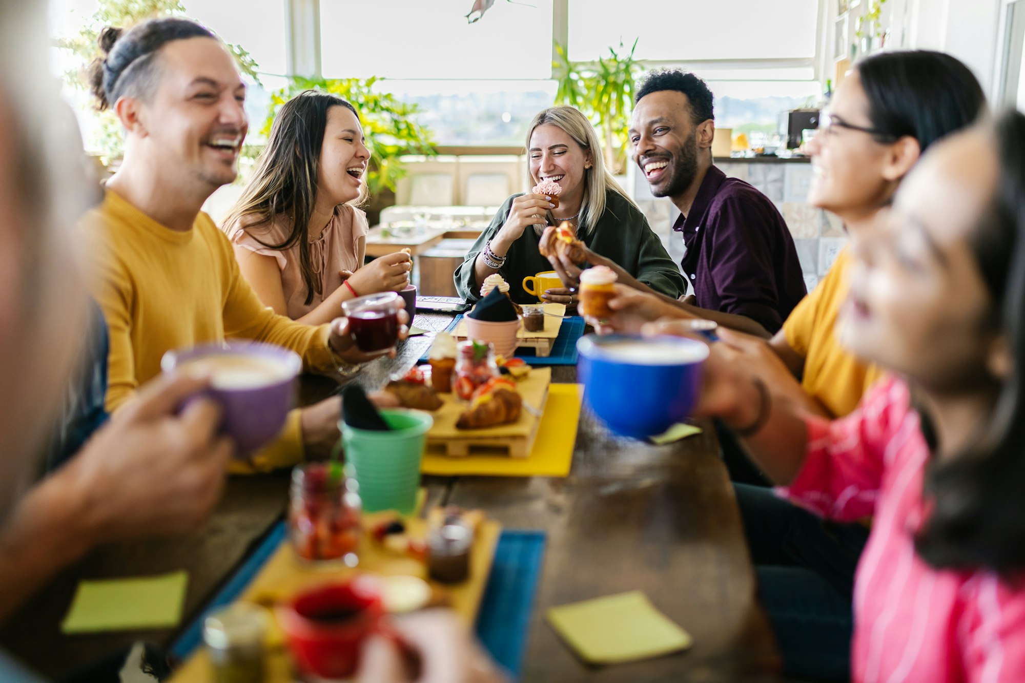 Multiracial people gathering together while having breakfast on rooftop cafe restaurant